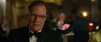 Movie still from “Seberg” (2019), directed by Benedict Andrews – An older man in a suit and bow tie; Close Up shot, Over the shoulder angle