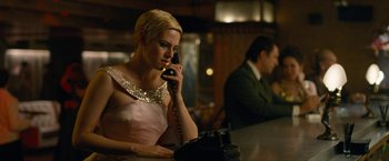 Movie still from “Seberg” (2019), directed by Benedict Andrews – A woman talking on a phone while sitting at a bar; Medium shot, High angle