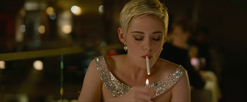 Movie still from “Seberg” (2019), directed by Benedict Andrews – A woman lighting a cigarette with a lit candle; Close Up shot, High angle