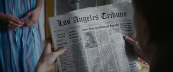 Movie still from “Seberg” (2019), directed by Benedict Andrews – A person is reading a newspaper with a picture of jean seberg on it; Extreme Close Up shot, High angle