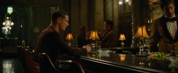 Movie still from “Seberg” (2019), directed by Benedict Andrews – A man sitting at a table in front of two other people; Medium shot, Over the shoulder angle