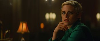 Movie still from “Seberg” (2019), directed by Benedict Andrews – A woman in a green shirt sitting in front of a window; Close Up shot, Over the shoulder angle