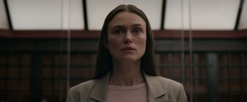 Movie still from “Official Secrets” (2019), directed by Gavin Hood – A woman with long brown hair wearing a jacket; Close Up shot, Low angle