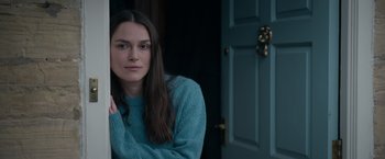 Movie still from “Official Secrets” (2019), directed by Gavin Hood – A woman sitting in front of an open door; Close Up shot, Over the shoulder angle