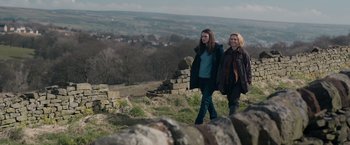 Movie still from “Official Secrets” (2019), directed by Gavin Hood – Two women are walking on a rocky hill side; Medium shot, Over the shoulder angle
