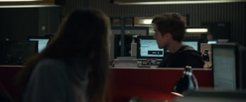 A man and a woman sitting in front of computers