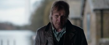 Movie still from “Official Secrets” (2019), directed by Gavin Hood – A person wearing a leather jacket; Close Up shot, Over the shoulder angle