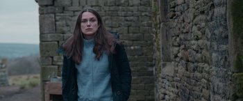 Movie still from “Official Secrets” (2019), directed by Gavin Hood – A woman standing in front of a brick wall; Medium shot, Over the shoulder angle