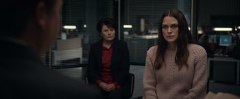 Movie still from “Official Secrets” (2019), directed by Gavin Hood – Two women are sitting in a glass room; Medium shot, Over the shoulder angle
