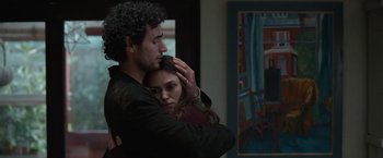 Movie still from “Official Secrets” (2019), directed by Gavin Hood – A man and a woman hugging in a room; Medium shot, Over the shoulder angle