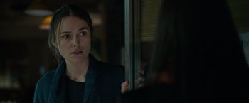 Movie still from “Official Secrets” (2019), directed by Gavin Hood – A woman standing in front of a window; Close Up shot, Over the shoulder angle