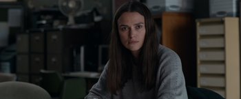 Movie still from “Official Secrets” (2019), directed by Gavin Hood – A woman with long hair sitting in front of a window; Close Up shot, Over the shoulder angle