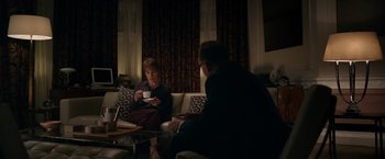 Movie still from “Official Secrets” (2019), directed by Gavin Hood – Two people sitting in a living room drinking coffee; Medium shot, Over the shoulder angle