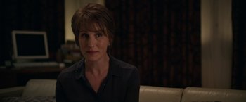 Movie still from “Official Secrets” (2019), directed by Gavin Hood – A person sitting on a couch in a room; Close Up shot, Over the shoulder angle