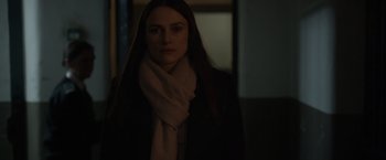 Movie still from “Official Secrets” (2019), directed by Gavin Hood – A woman wearing a black jacket and a white scarf; Close Up shot, Over the shoulder angle