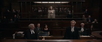 Movie still from “Official Secrets” (2019), directed by Gavin Hood – A woman standing in front of a judge in a courtroom; Wide shot, Low angle