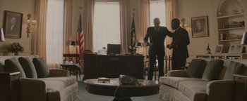 Movie still from “Selma” (2014), directed by Ava DuVernay – Two men in suits in a living room with a desk; Wide shot, Low angle