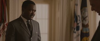 Movie still from “Selma” (2014), directed by Ava DuVernay – A man wearing a suit and tie standing in front of a window; Close Up shot, Over the shoulder angle
