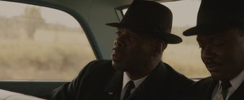 Movie still from “Selma” (2014), directed by Ava DuVernay – A man wearing a suit and a hat sitting in a car; Close Up shot, Low angle