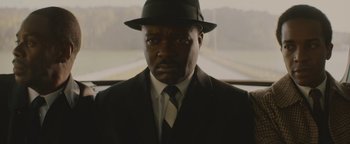 Movie still from “Selma” (2014), directed by Ava DuVernay – A man wearing a suit and hat in front of a window; Close Up shot, Low angle