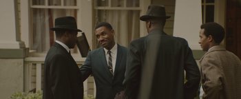 Movie still from “Selma” (2014), directed by Ava DuVernay – A man in a suit talking to two other men; Medium shot, Over the shoulder angle