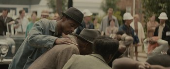 Movie still from “Selma” (2014), directed by Ava DuVernay – A group of people sitting around each other in a crowd; Close Up shot, Over the shoulder angle