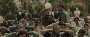 Movie still from “Selma” (2014), directed by Ava DuVernay – A group of people sitting on the ground; Medium shot, Over the shoulder angle