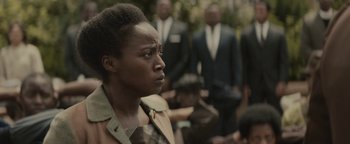 Movie still from “Selma” (2014), directed by Ava DuVernay – A woman looking to her left in front of a group of men; Close Up shot, Over the shoulder angle