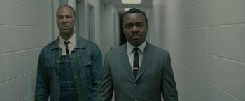Movie still from “Selma” (2014), directed by Ava DuVernay – A man in a suit and tie standing next to another man in a suit; Medium shot, Low angle