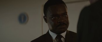 Movie still from “Selma” (2014), directed by Ava DuVernay – A man in a suit and tie looking at the camera; Close Up shot, Low angle