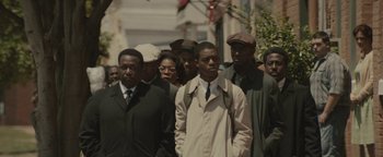 Movie still from “Selma” (2014), directed by Ava DuVernay – A group of people standing next to each other on the street; Medium shot, Over the shoulder angle