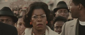 Movie still from “Selma” (2014), directed by Ava DuVernay – An older black woman wearing glasses in a crowd of people; Close Up shot, Low angle