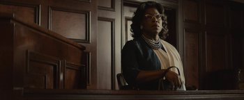Movie still from “Selma” (2014), directed by Ava DuVernay – A woman sitting at a table in front of a wooden wall; Medium shot, Low angle