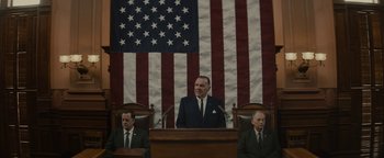 Movie still from “Selma” (2014), directed by Ava DuVernay – A man is speaking at a podium in front of an american flag; Medium shot, Low angle