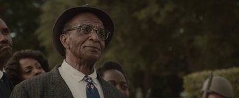 Movie still from “Selma” (2014), directed by Ava DuVernay – An older man wearing a hat and glasses; Close Up shot, Over the shoulder angle