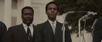 Movie still from “Selma” (2014), directed by Ava DuVernay – A man in a suit and tie standing next to another man in a suit and tie; Close Up shot, Low angle
