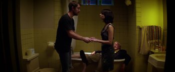 A man and a woman holding hands in front of an old man