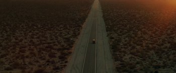 An aerial view of a car driving down a road