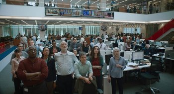Movie still from “She Said” (2022), directed by Maria Schrader – A group of people standing in an office; Wide shot, Low angle