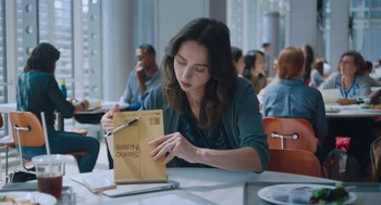 Movie still from “She Said” (2022), directed by Maria Schrader – A woman sitting at a table with a book; Close Up shot, Over the shoulder angle
