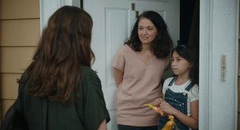 Movie still from “She Said” (2022), directed by Maria Schrader – A woman standing next to two other women; Medium shot, Over the shoulder angle