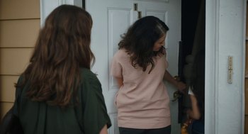 Movie still from “She Said” (2022), directed by Maria Schrader – Two young women standing in front of a white door; Medium shot, Over the shoulder angle