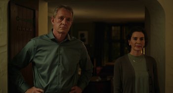Movie still from “She Said” (2022), directed by Maria Schrader – A man and a woman standing next to each other in a room; Medium shot, Low angle