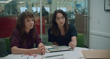 Movie still from “She Said” (2022), directed by Maria Schrader – Two women sitting at a table in an office setting; Medium shot, Over the shoulder angle