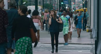 Movie still from “She Said” (2022), directed by Maria Schrader – A group of people walking across a busy street; Wide shot, Over the shoulder angle
