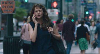 Movie still from “She Said” (2022), directed by Maria Schrader – A woman talking on a cell phone while walking down the street; Medium shot, Low angle