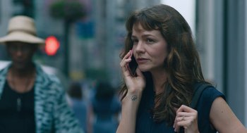 Movie still from “She Said” (2022), directed by Maria Schrader – A beautiful woman with long brown hair talking on a cell phone; Close Up shot, Low angle
