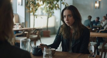 Movie still from “She Said” (2022), directed by Maria Schrader – A woman sitting at a table in a restaurant; Close Up shot, Over the shoulder angle