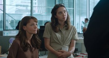 Movie still from “She Said” (2022), directed by Maria Schrader – Two women are standing in an office looking at something; Medium shot, Over the shoulder angle