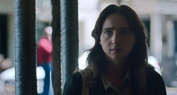 Movie still from “She Said” (2022), directed by Maria Schrader – A person wearing a suit and tie; Close Up shot, Over the shoulder angle